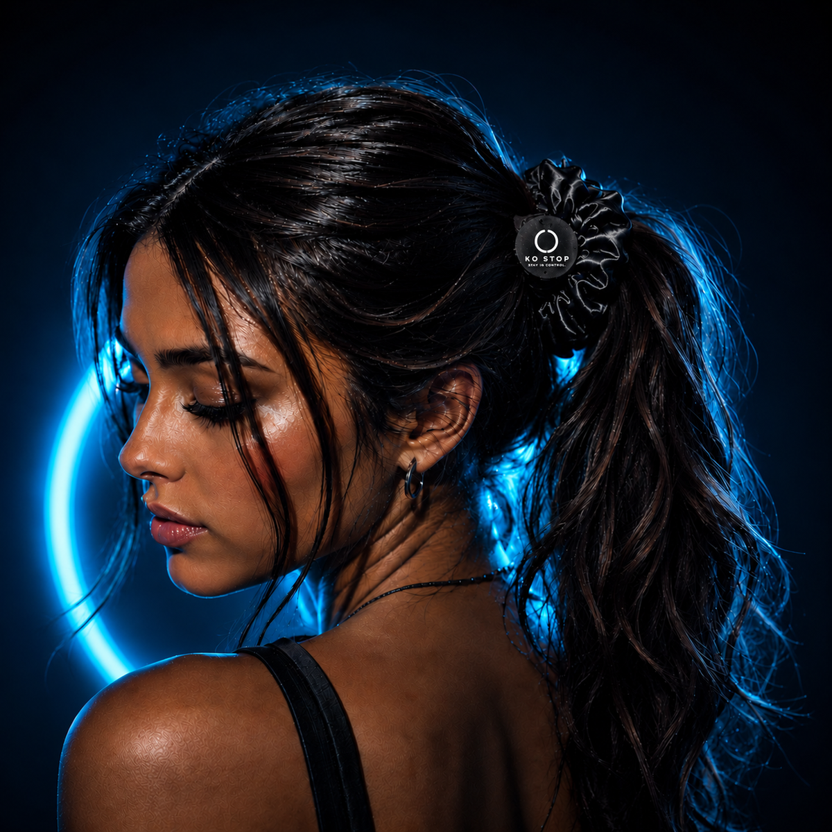 Schwarzer KO STOP Scrunchie mit weißem Logo als Haarband im Pferdeschwanz.