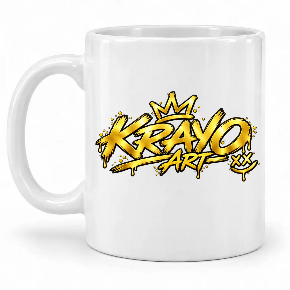 Weiße Tasse mit goldfarbenem Krayo-Art-Schriftzug, Krone und Smiley mit X-Augen im Graffiti-Stil; Henkel links.